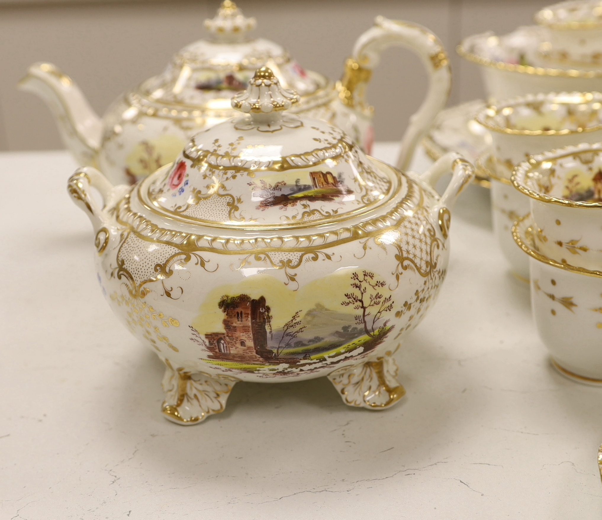 An early 19th century H & R Daniel landscape painted tea and coffee set, including twelve tea cups and saucers, twelve coffee cups, a teapot, a jug and a covered serving bowl, teapot 15cm high